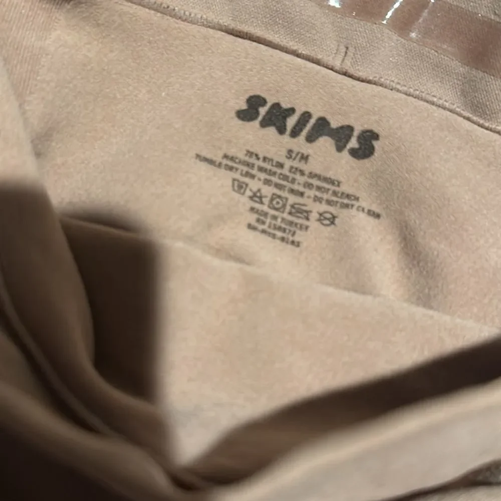 SKIMS high-waisted mid thigh short in color sienna in the size Small